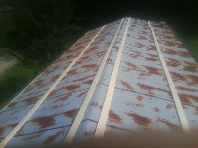 Rusted metal roof panels with new wood purlins before replacement — Storm Damage Roof Repair in Batson by Roofing Brothers