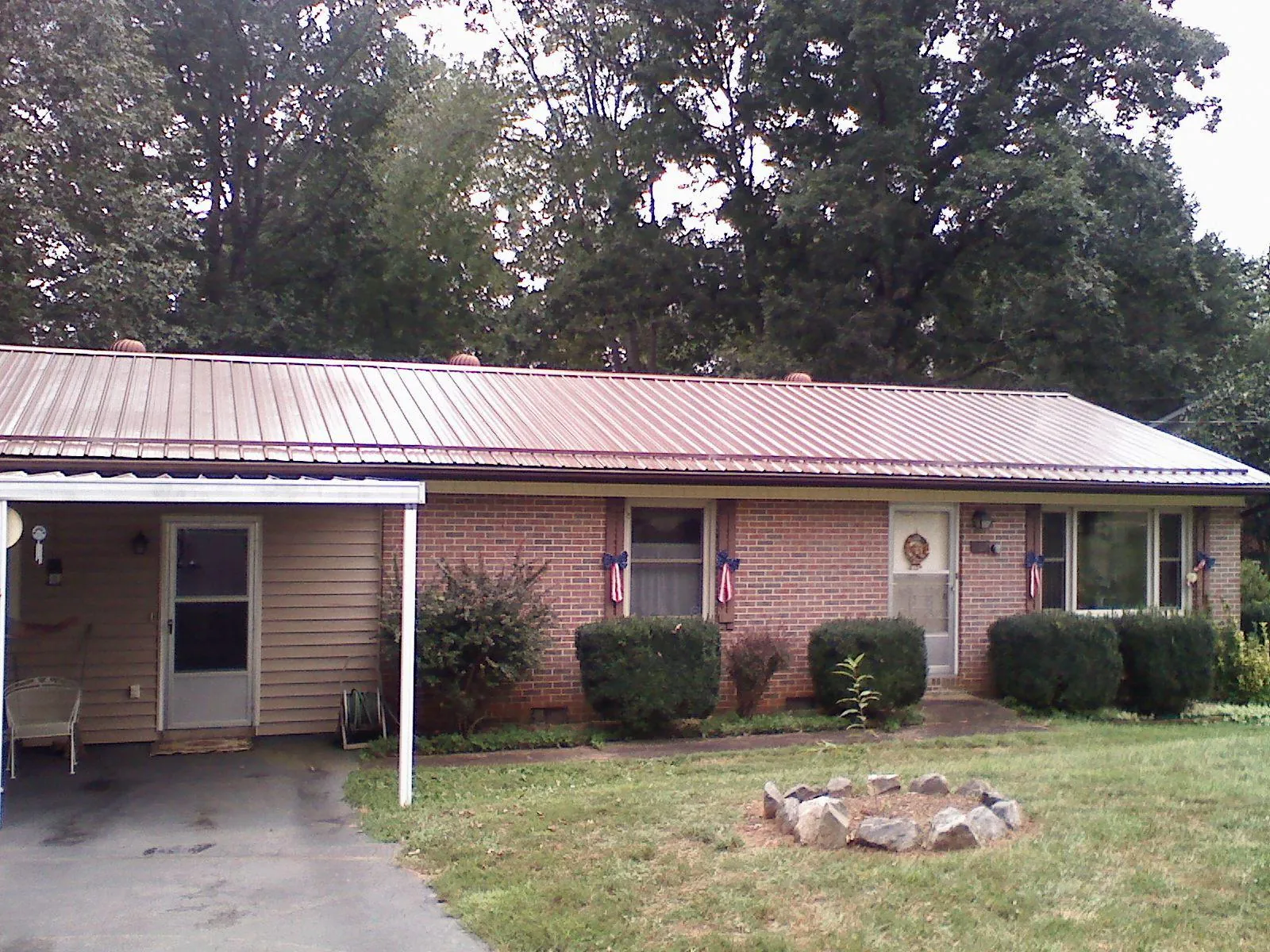 Bronze metal roof and carport on a brick ranch home — Roof Repair work by our crew in Batson