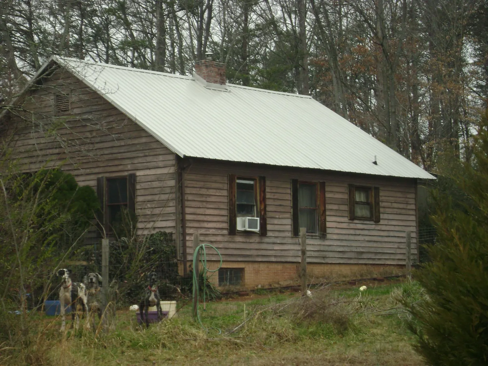 White metal roof on an old wood sided farmhouse, from a Metal Roof Installation job in Batson